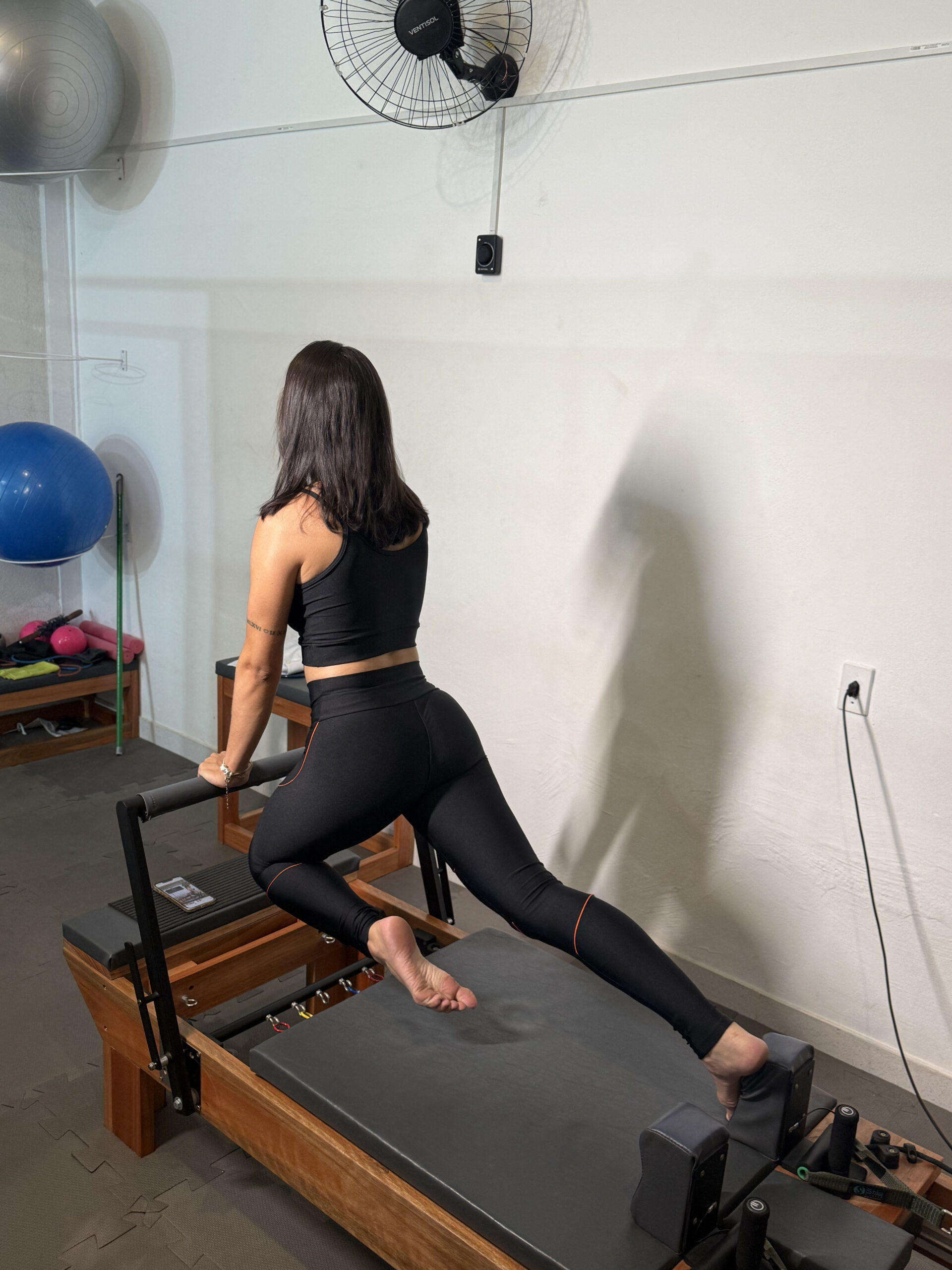 Instrutora de Pilates demonstrando realização correta do exercício no bairro Cabral, em Contagem